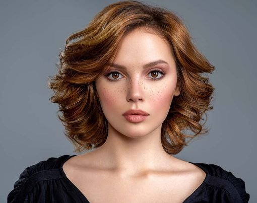 Beautiful brown haired with stylish short hairstyle. Woman with a  curly hair. Beautiful young woman with freckles on face.  Closeup portrait of an attractive girl  with a brown makeup.