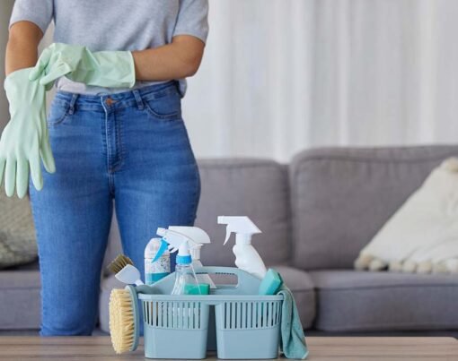 Black woman hands for cleaning, product in basket on table for home maintenance tools or living room spring cleaning. Cleaner, container or maid with brush or liquid spray bottle for cleaning service