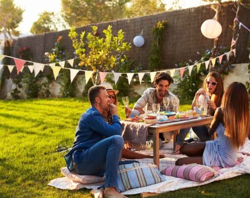 Group Of Friends Enjoying Outdoor Picnic In Garden