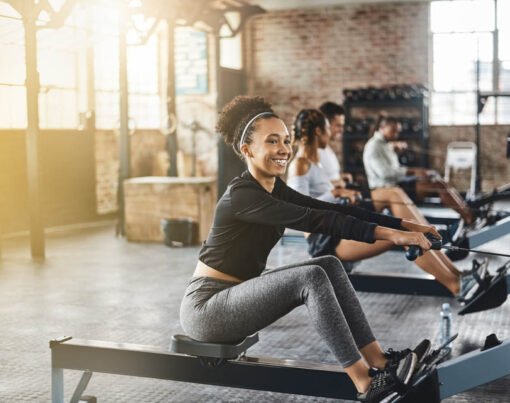 Group, rowing machine and training in gym, class or fitness work