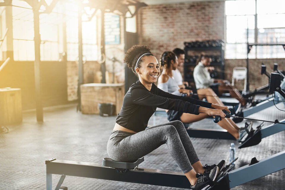 Group, rowing machine and training in gym, class or fitness work